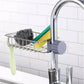 Kitchen sink caddy with sponge, scrubber, and brush attached to a faucet.