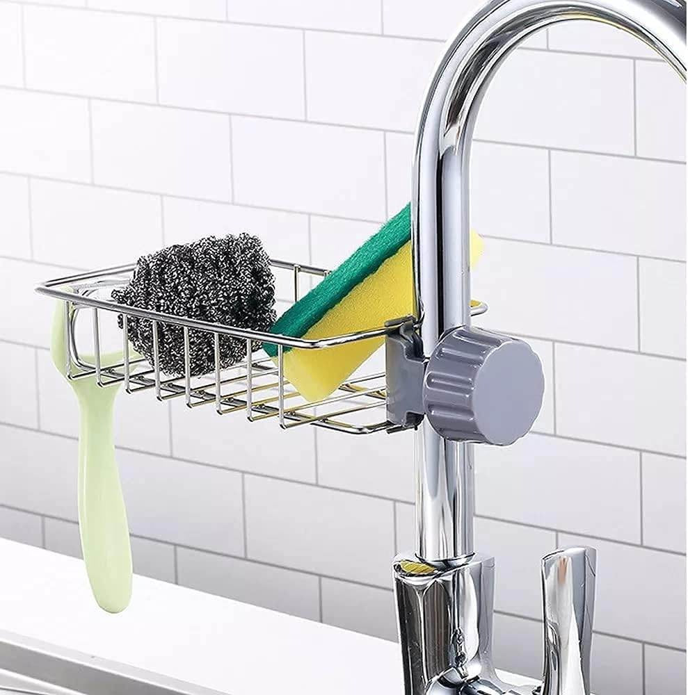 Kitchen sink caddy with sponge, scrubber, and brush attached to a faucet.