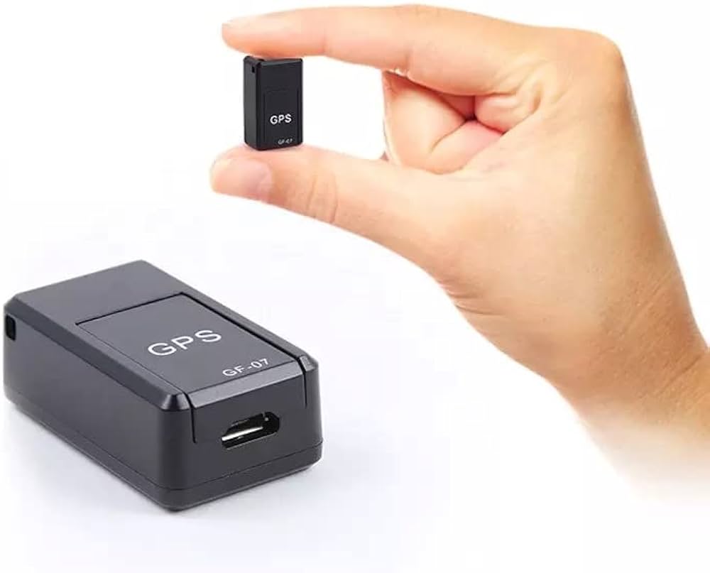 Small GPS tracker held by a hand on a white background