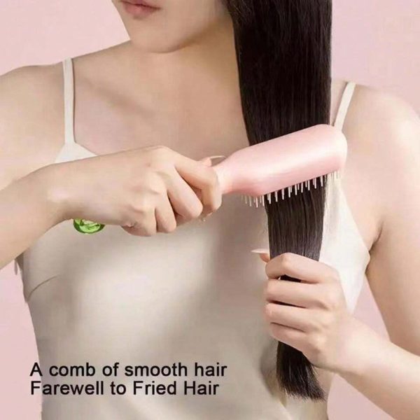 Person using a comb on smooth hair with a pink background
