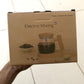 Box of an electric mixing cup with a glass product on a tiled floor.